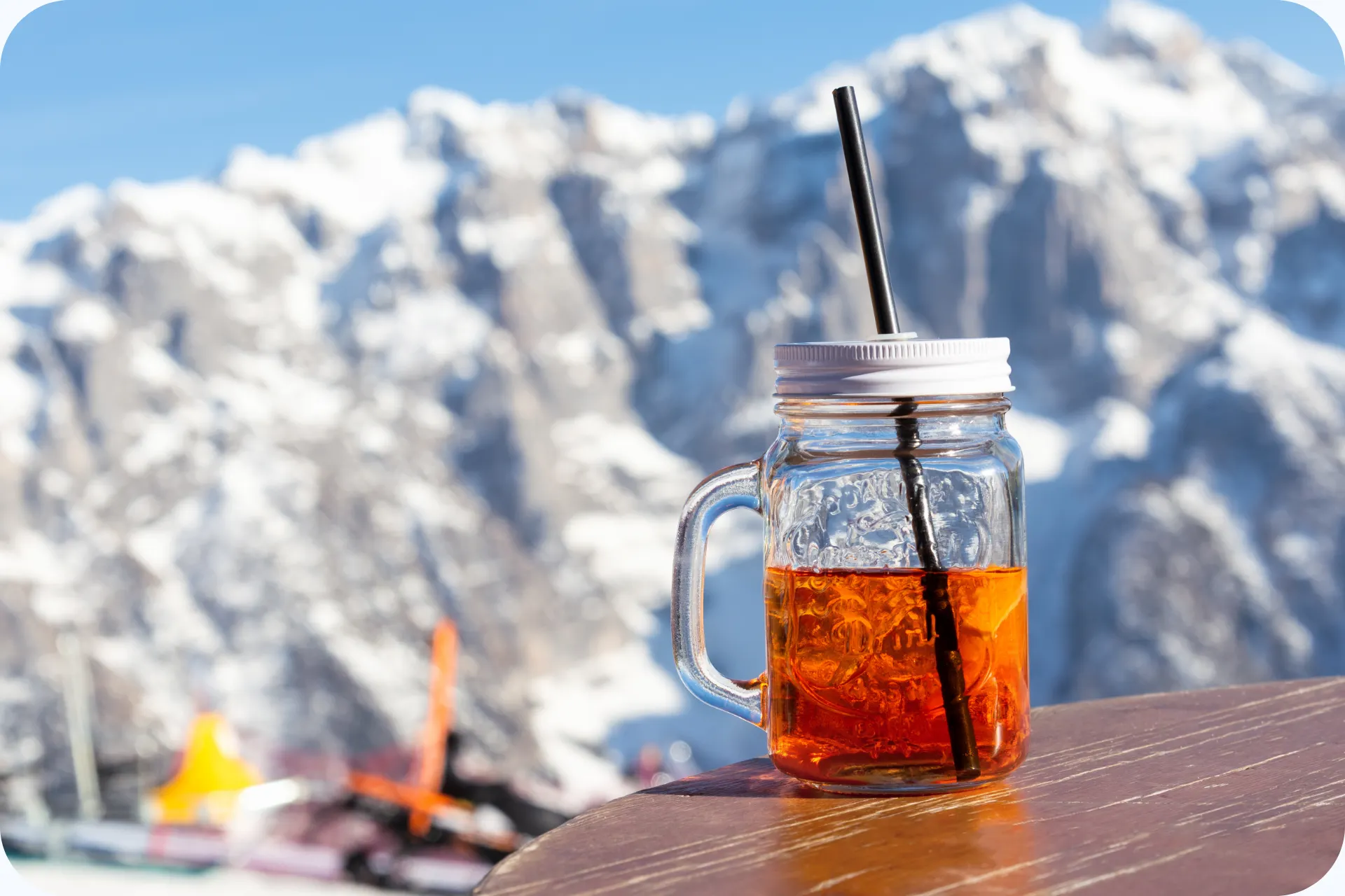 Aperol Spritz in een glas met uitzicht op besneeuwde bergen.