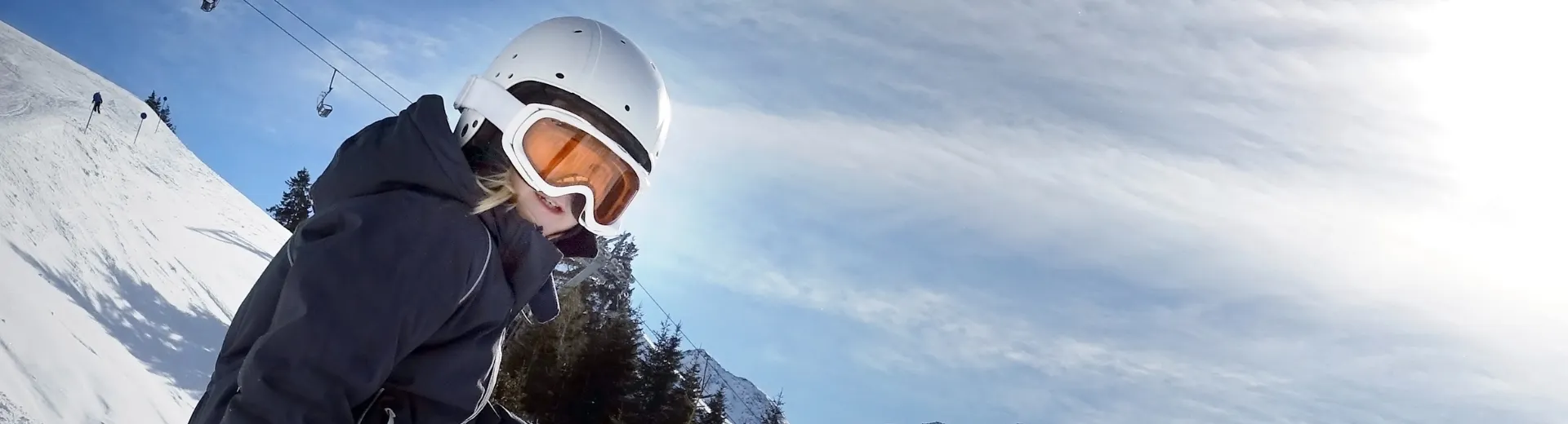 Een blij kind dat aan het skiën is, met op de achtergrond een skilift