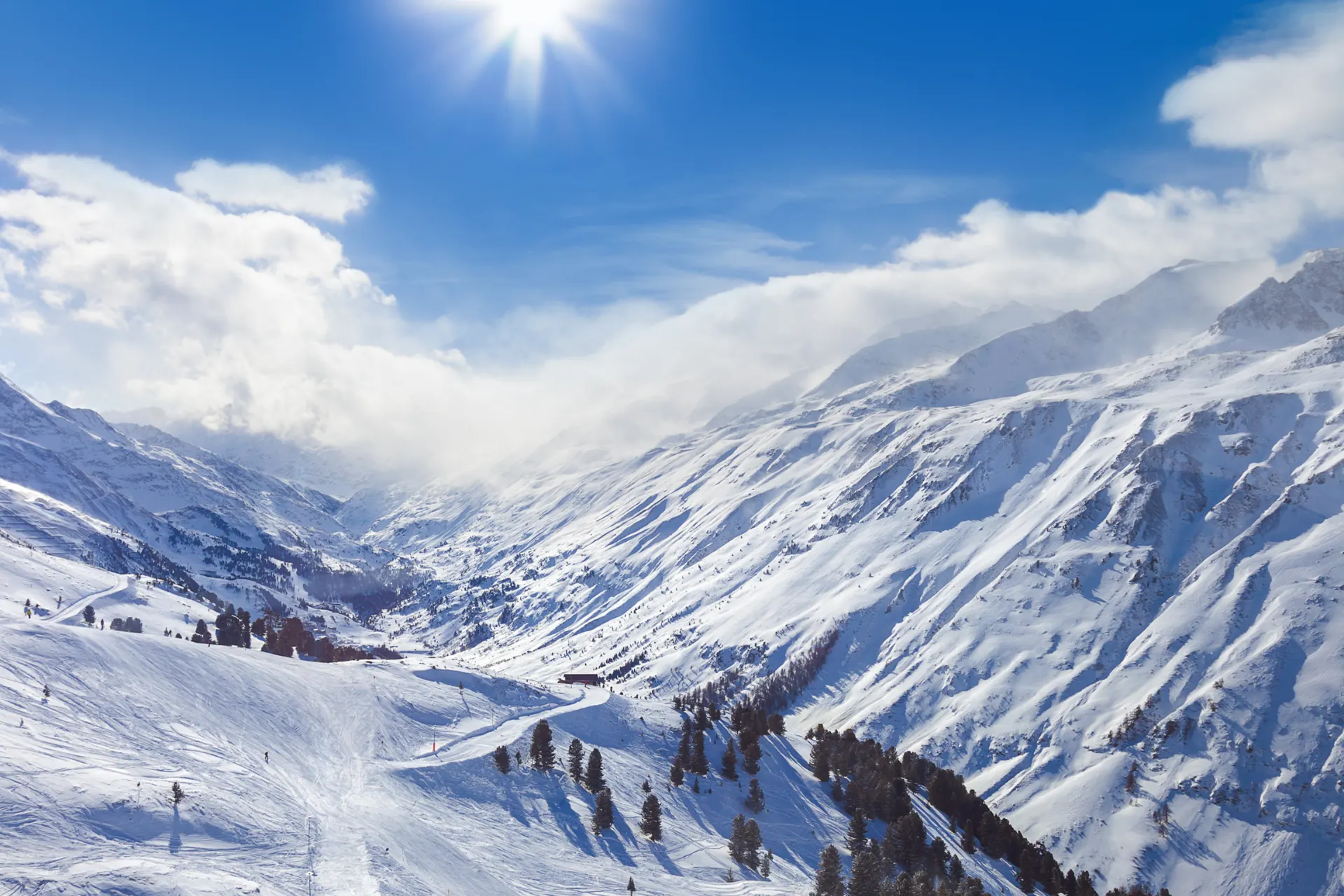 Uitzicht over de bergen en de pistes in het zonnetje