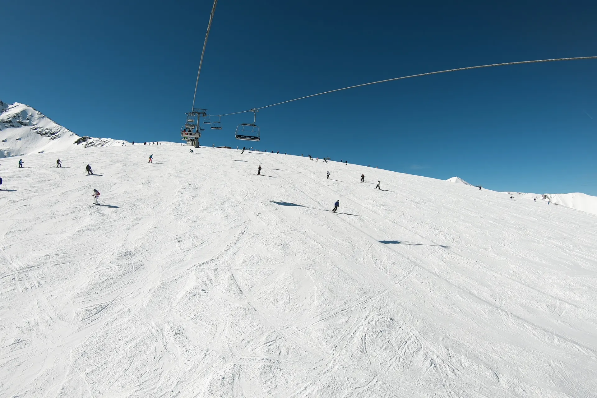 Zonnige piste met skiërs en een skilift