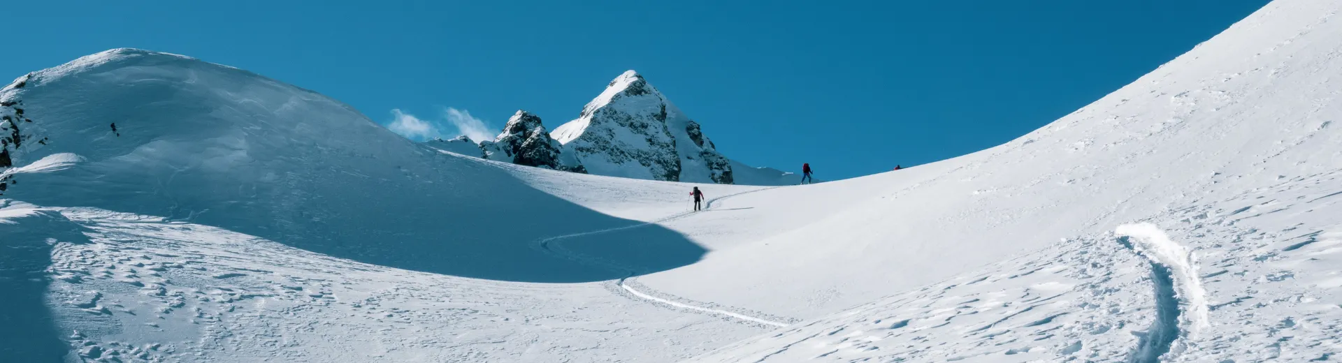 Skiërs die een berg afskiën.