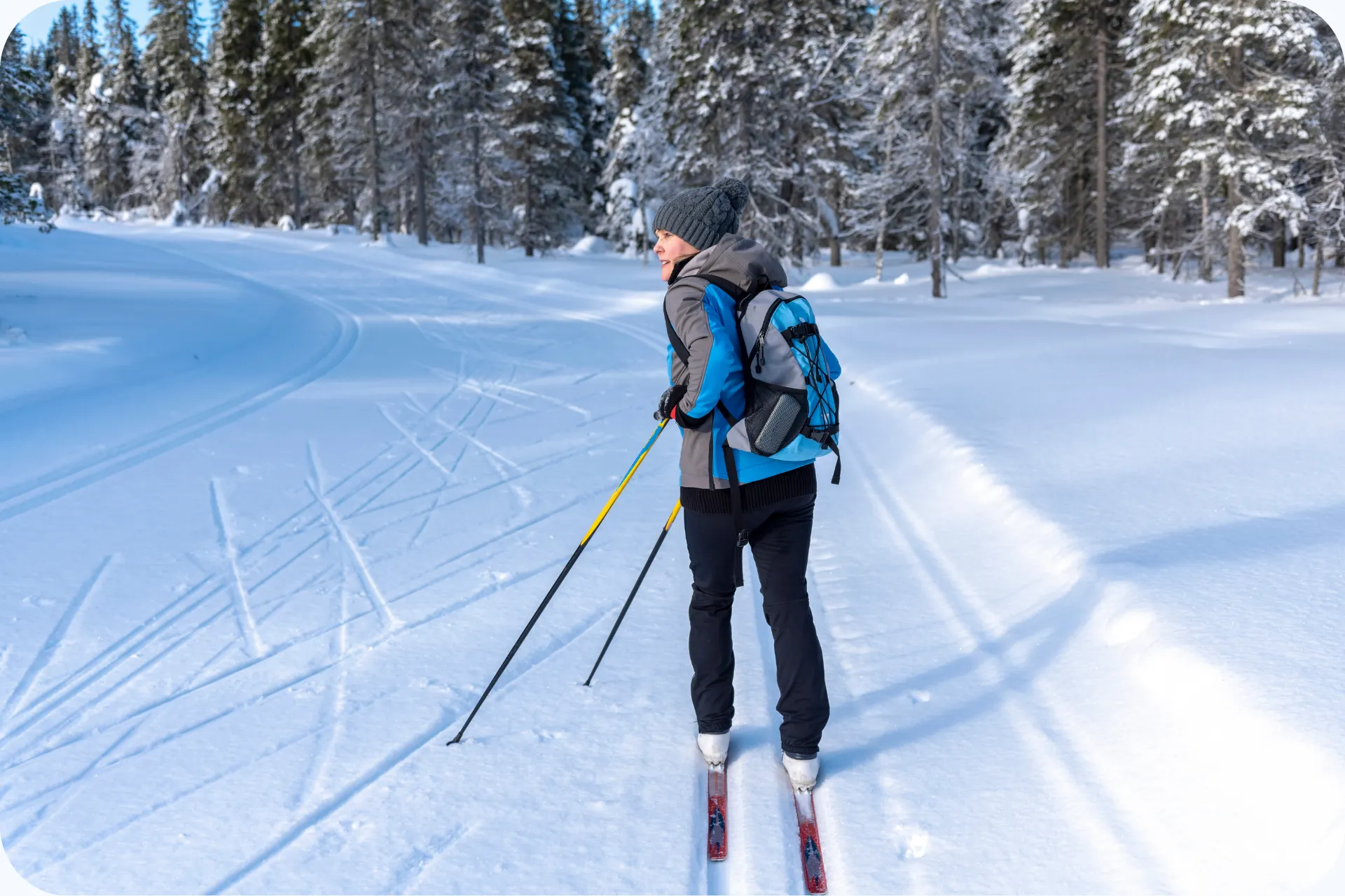 Vrouw die aan het langlaufen is door de sneeuw.