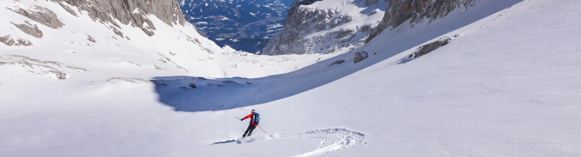 Een skiër die een afdaling maakt op de berg Hochköning
