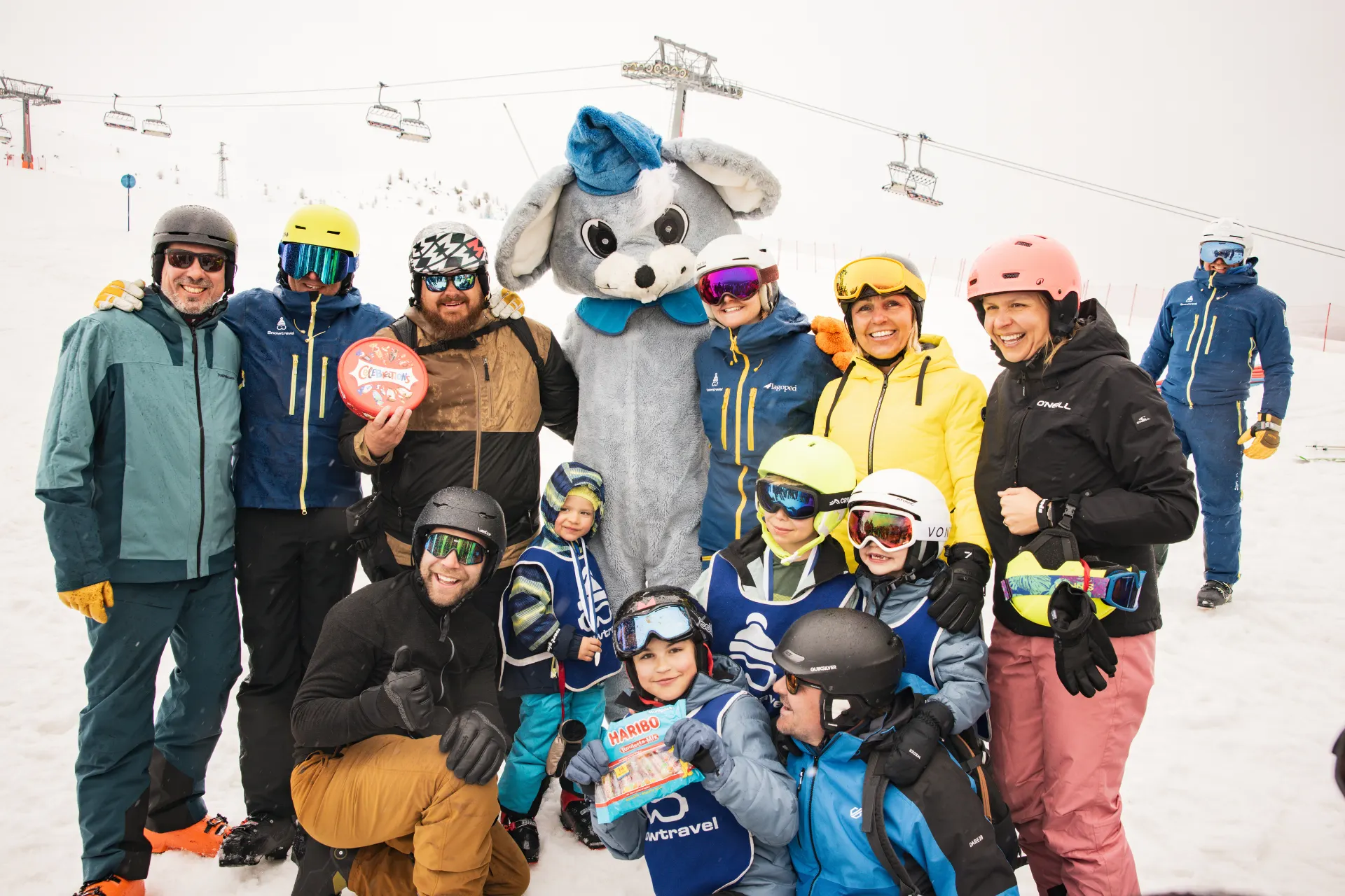 Snowie mascotte met kinderen en volwassenen.