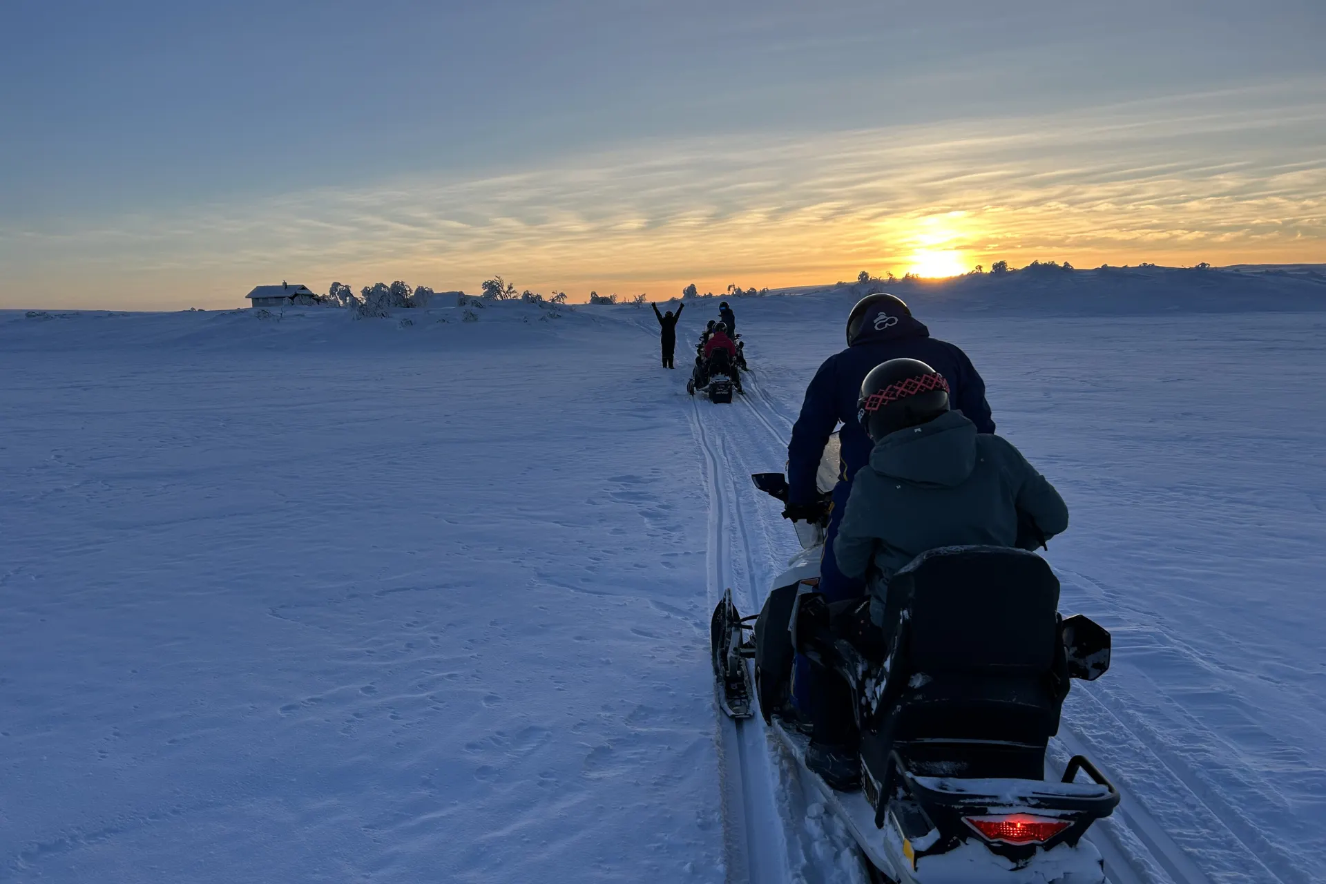 Met de sneeuwscooter op pad met zonsondergang in Noorwegen.