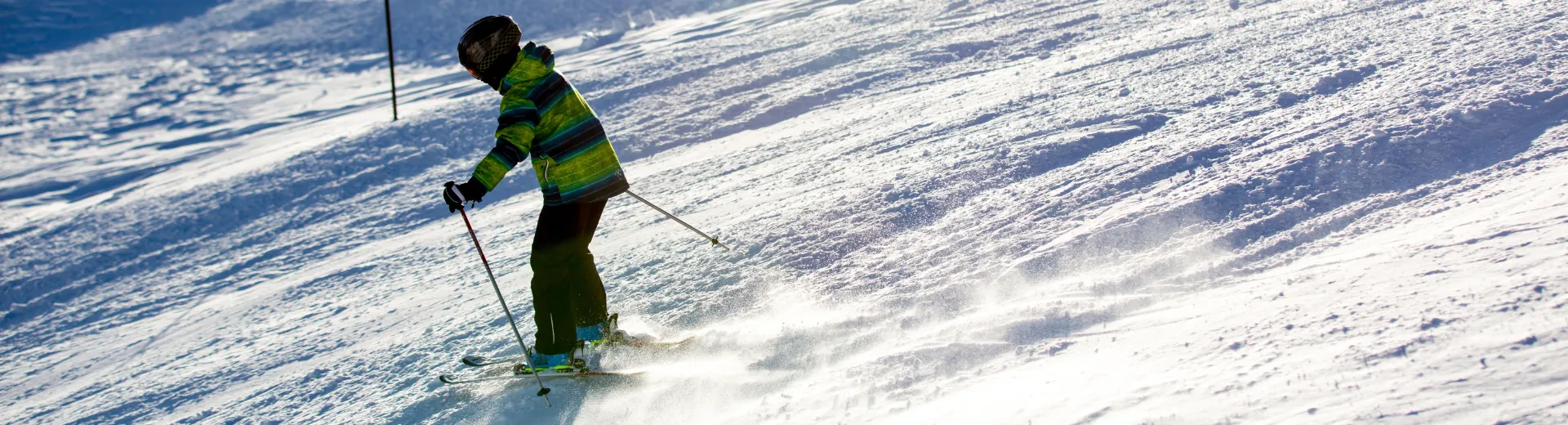 Een skiër die de piste afgaat.