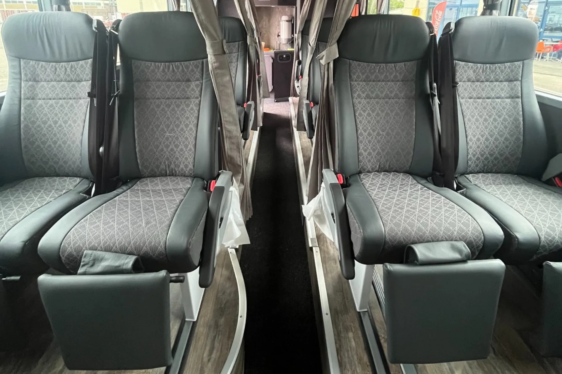 Een rij van 4 stoelen naast elkaar in een Premium Class bus