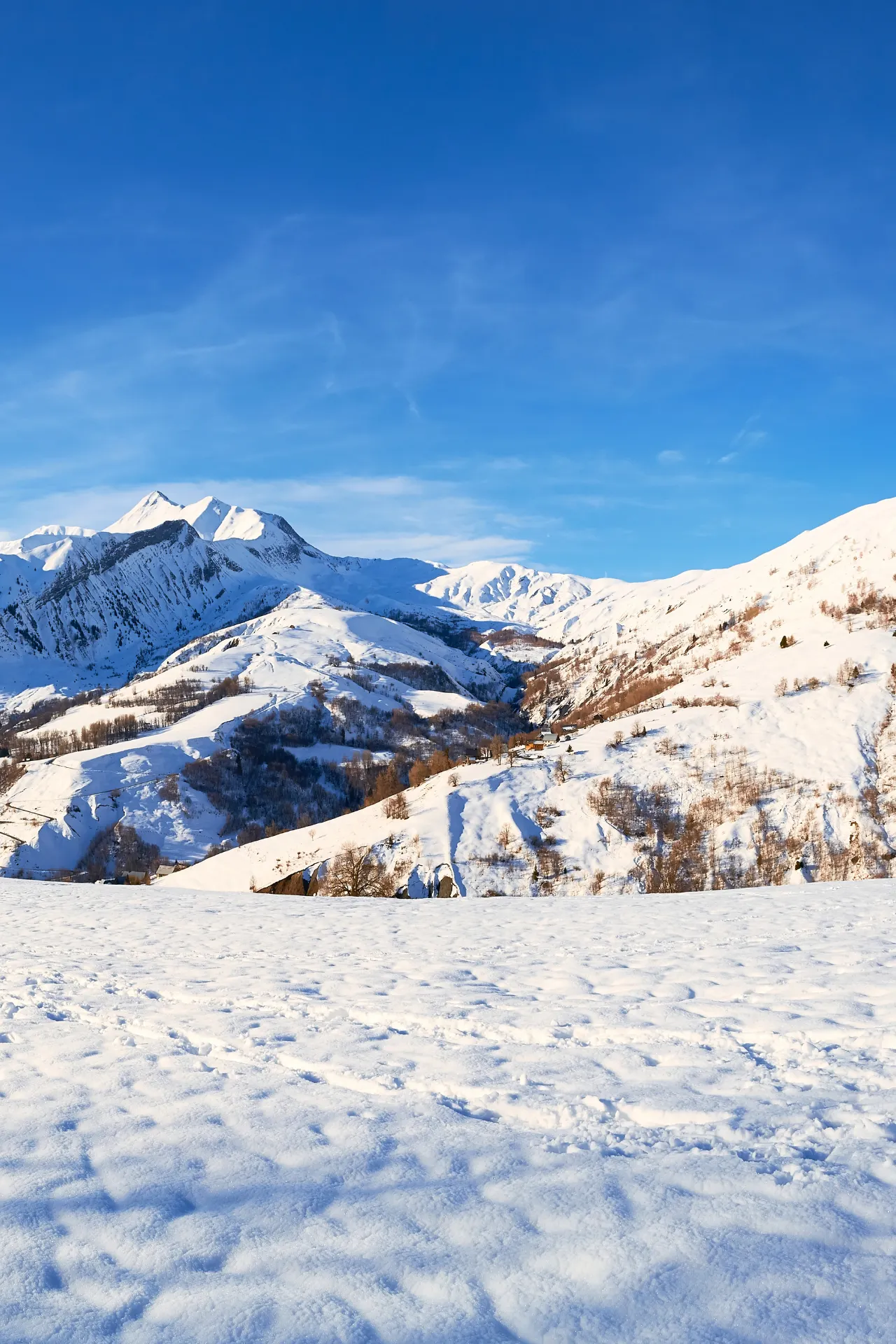 Skigebied met helderblauwe lucht en een witte piste
