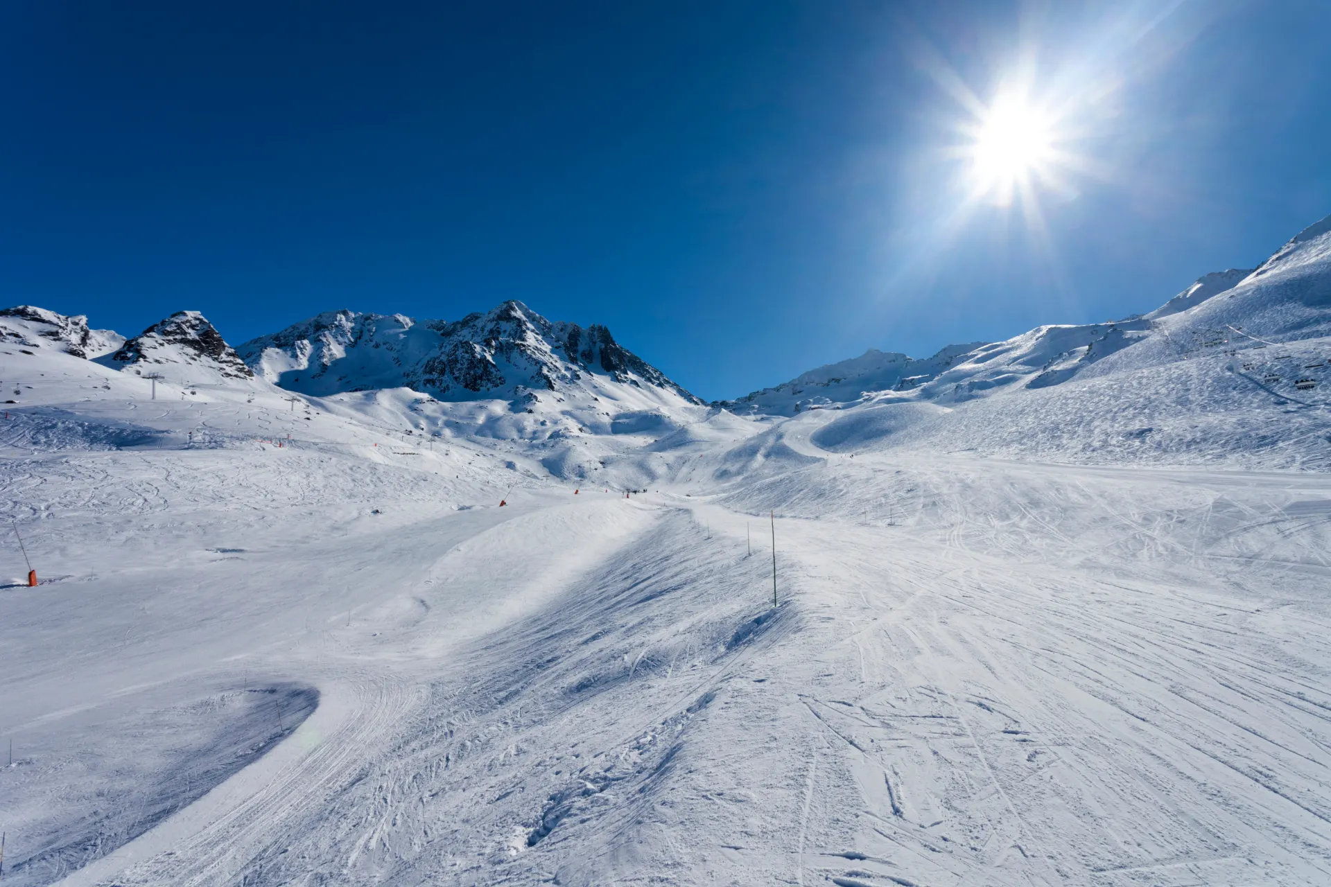 Piste met een strak blauwe lucht en de zon