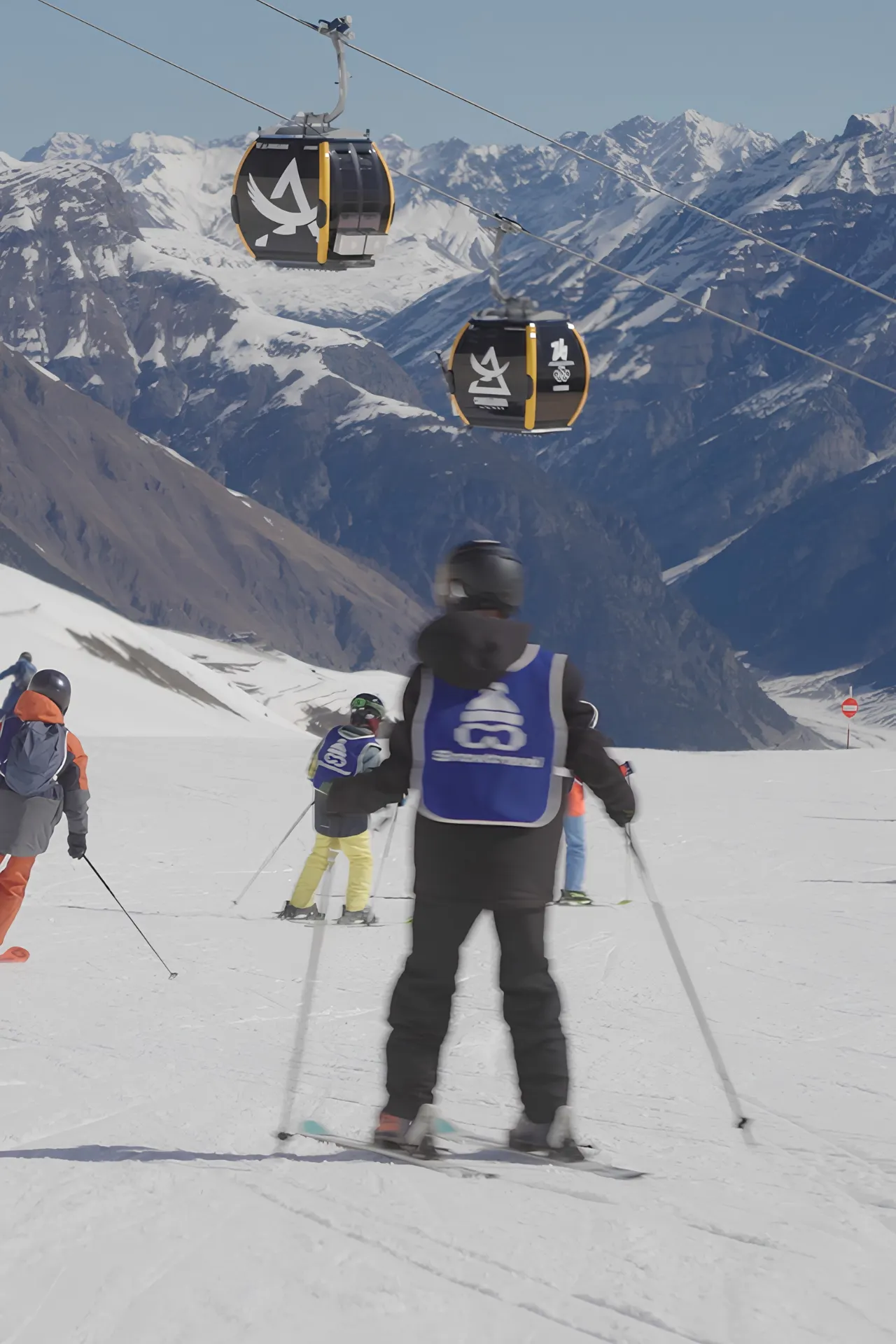 Monitor van Snowtravel die de berg af aan het skiën is met kinderen 