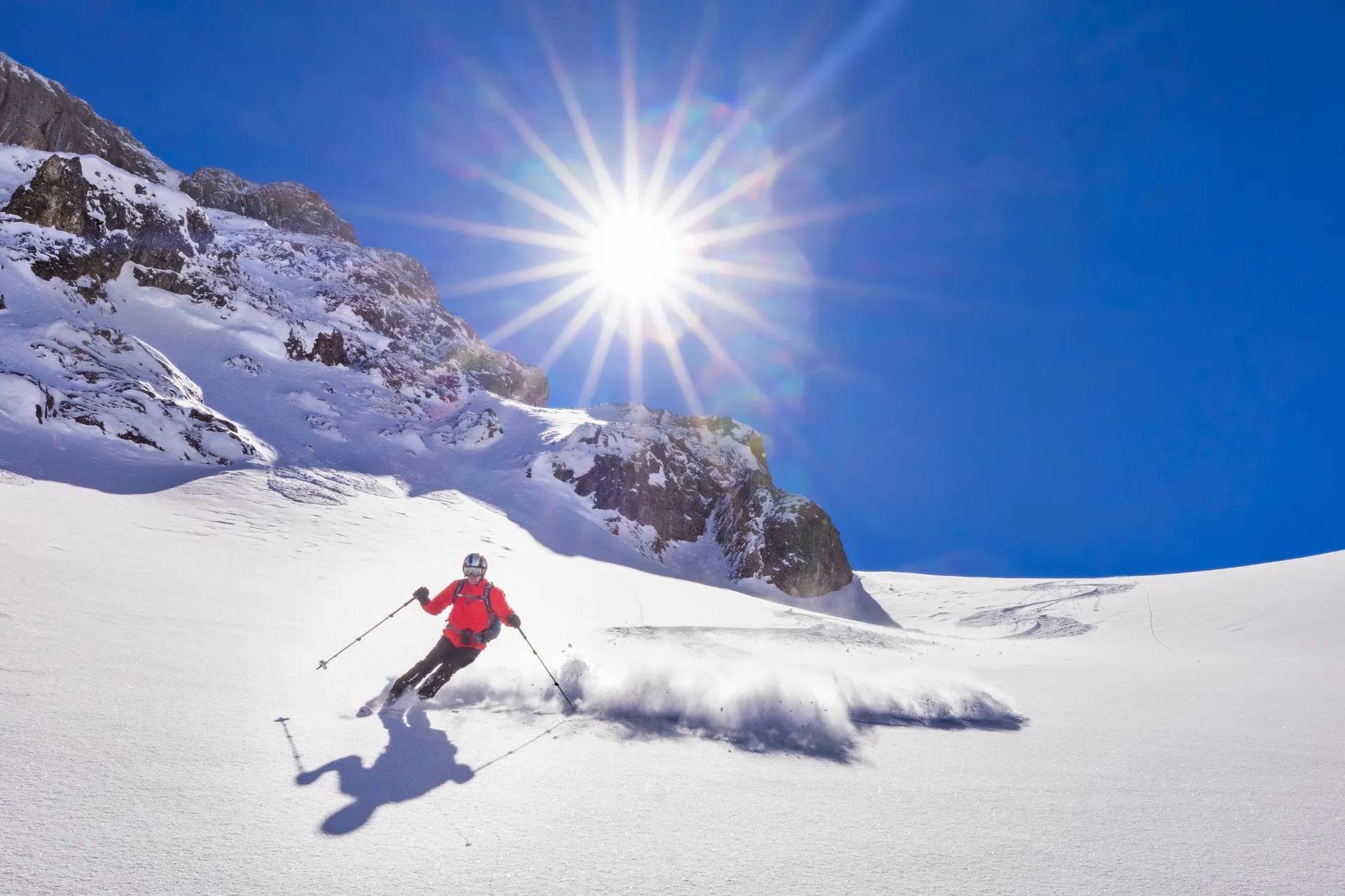 Een skiër die in de felle zon een afdaling inzet op de berg Hochkönig