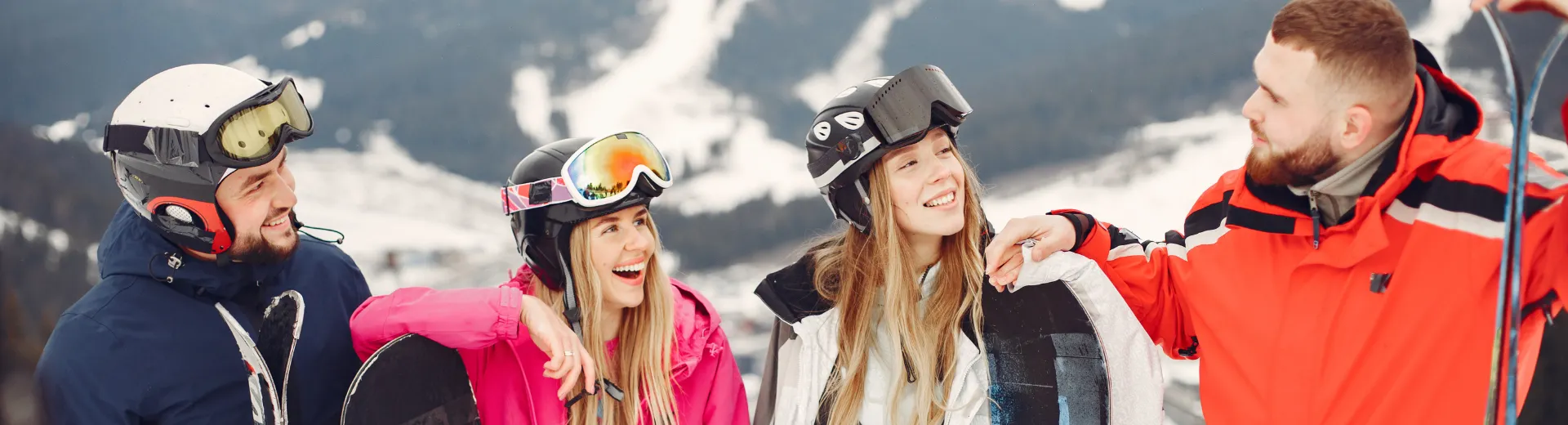 Groep studenten lachend op de piste in Oostenrijk.