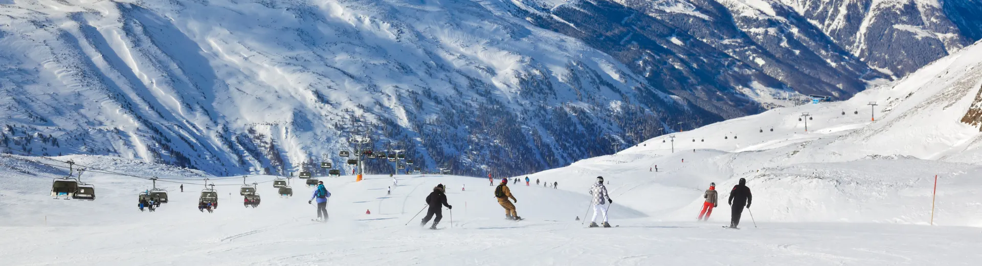 Links een skilift en in het midden een afdaling waarop verschillende skiërs te zien zijn
