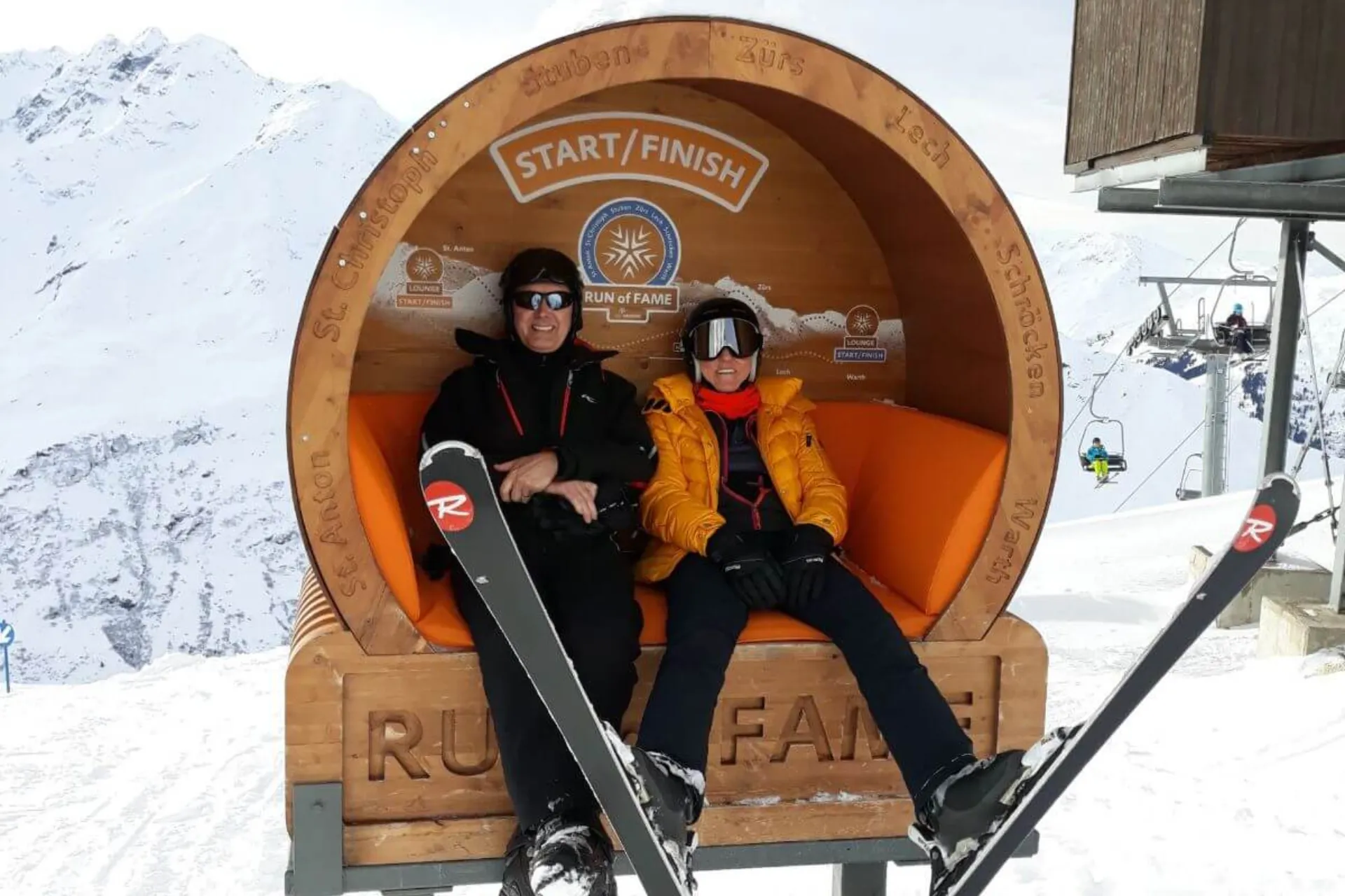Trouwe klant van Snowtravel Paul Piedfort en zijn vrouw op een bankje in een houten ton in de sneeuw.