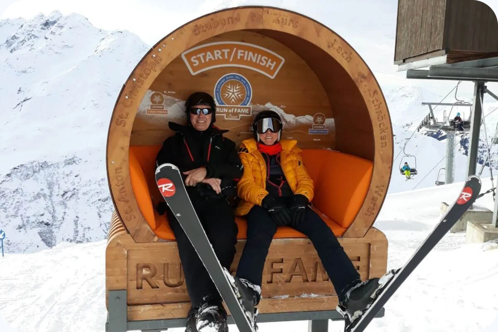 Twee trouwe klanten van Snowtravel in een bankje in een ton met de skies aan.