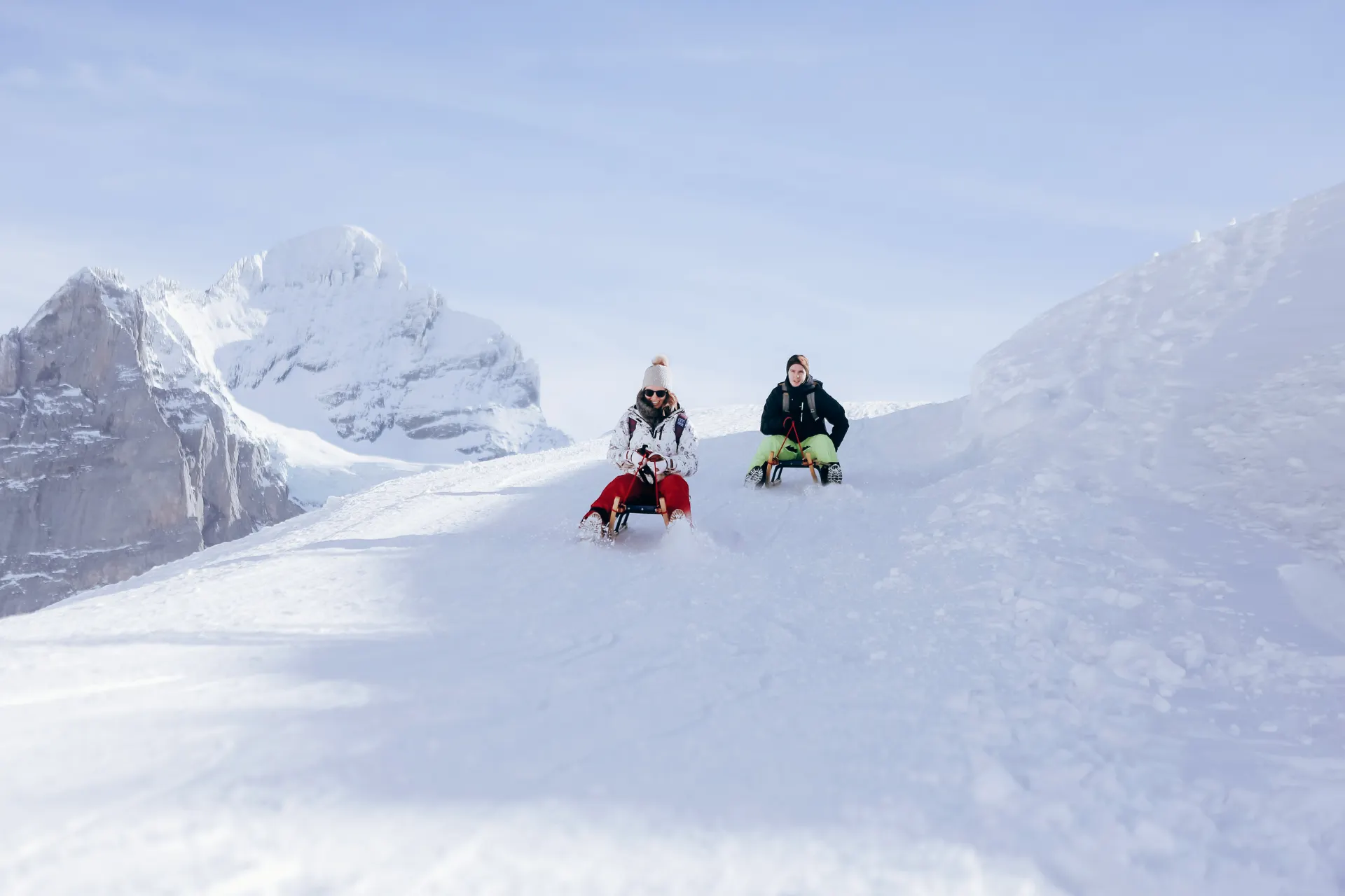 Twee mensen die de berg af sleeën in Oostenrijk