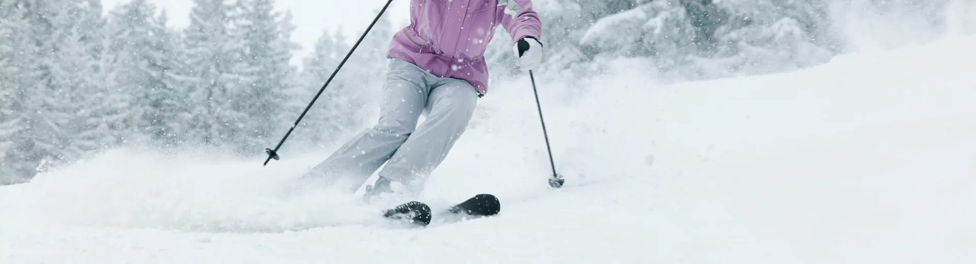 Ingezoomd op het onderlichaam van een skiër die aan het skiën is.
