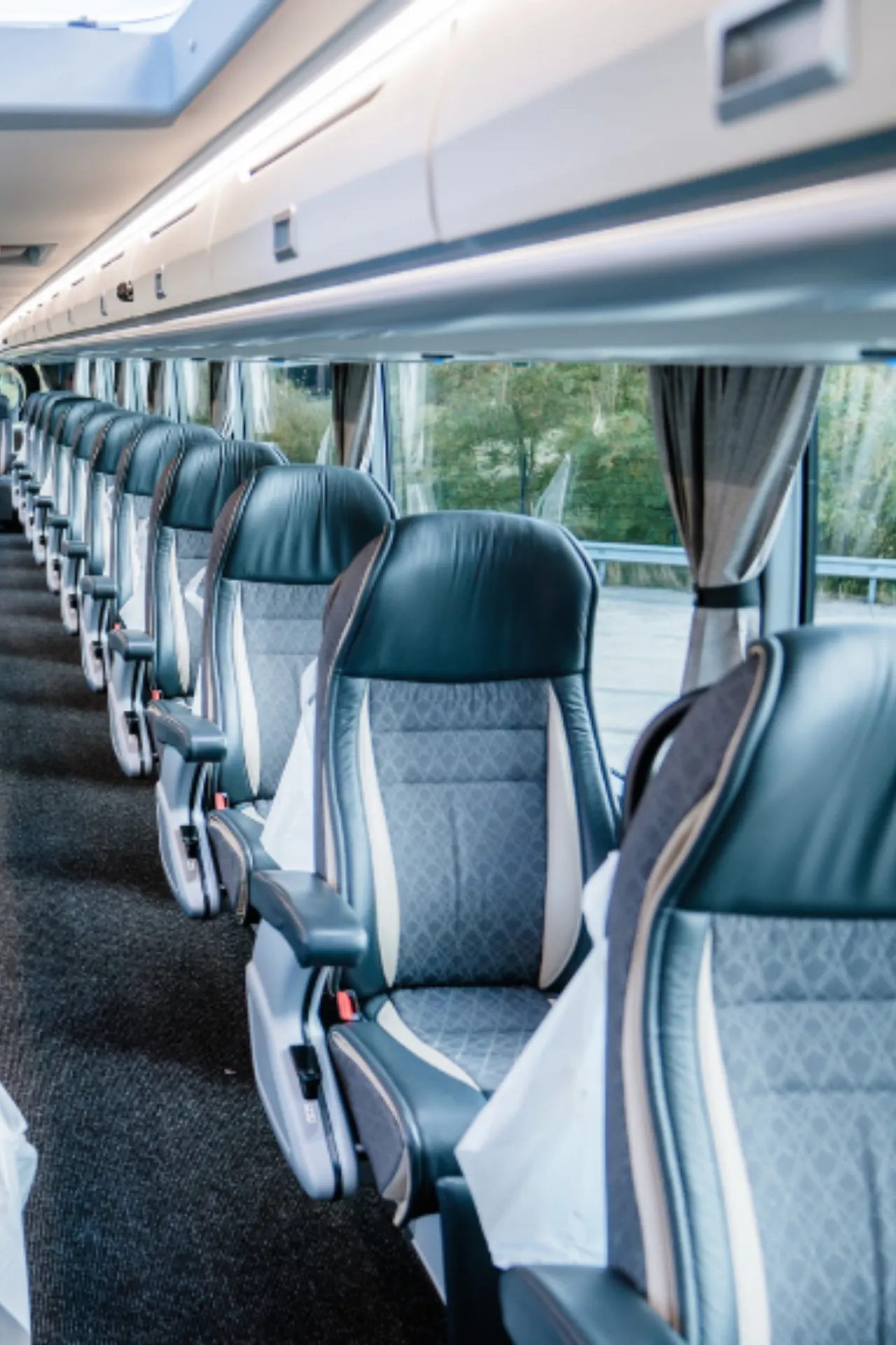 Een rij stoelen achter elkaar in de First Class bus